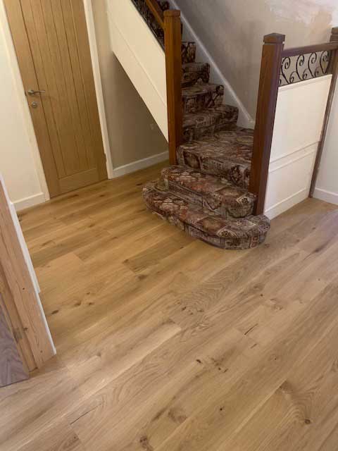 Completed wooden flooring at the bottom of the stairs.