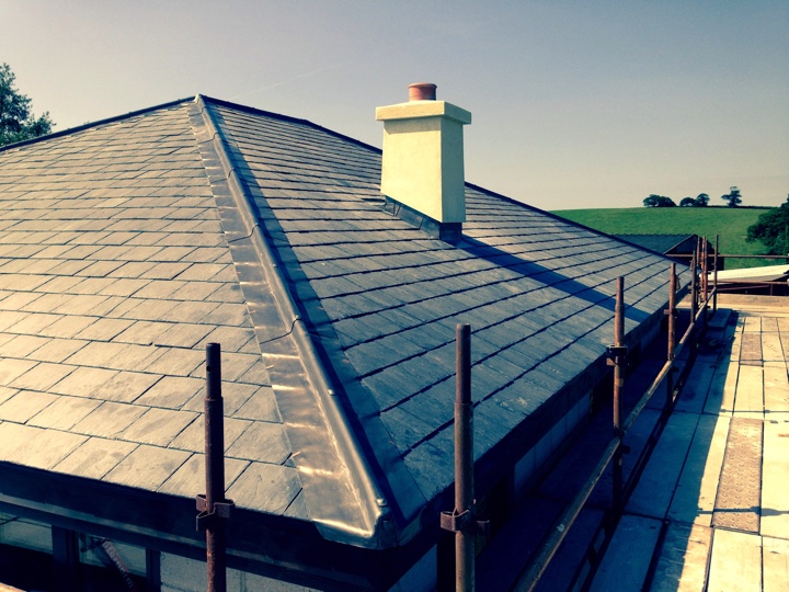 Roofing that has been repaired with dark tiles.